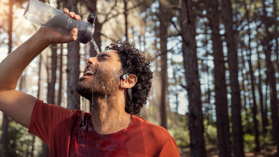 Muž používa bezdrôtové športové slúchadlá Philips počas tréningu vonku.