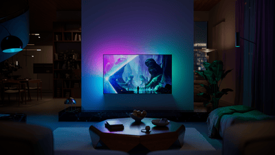 Philips Ambilight TV mounted in a modern living room, displaying a vibrant fantasy scene with colorful ambient lighting extending onto the wall.
