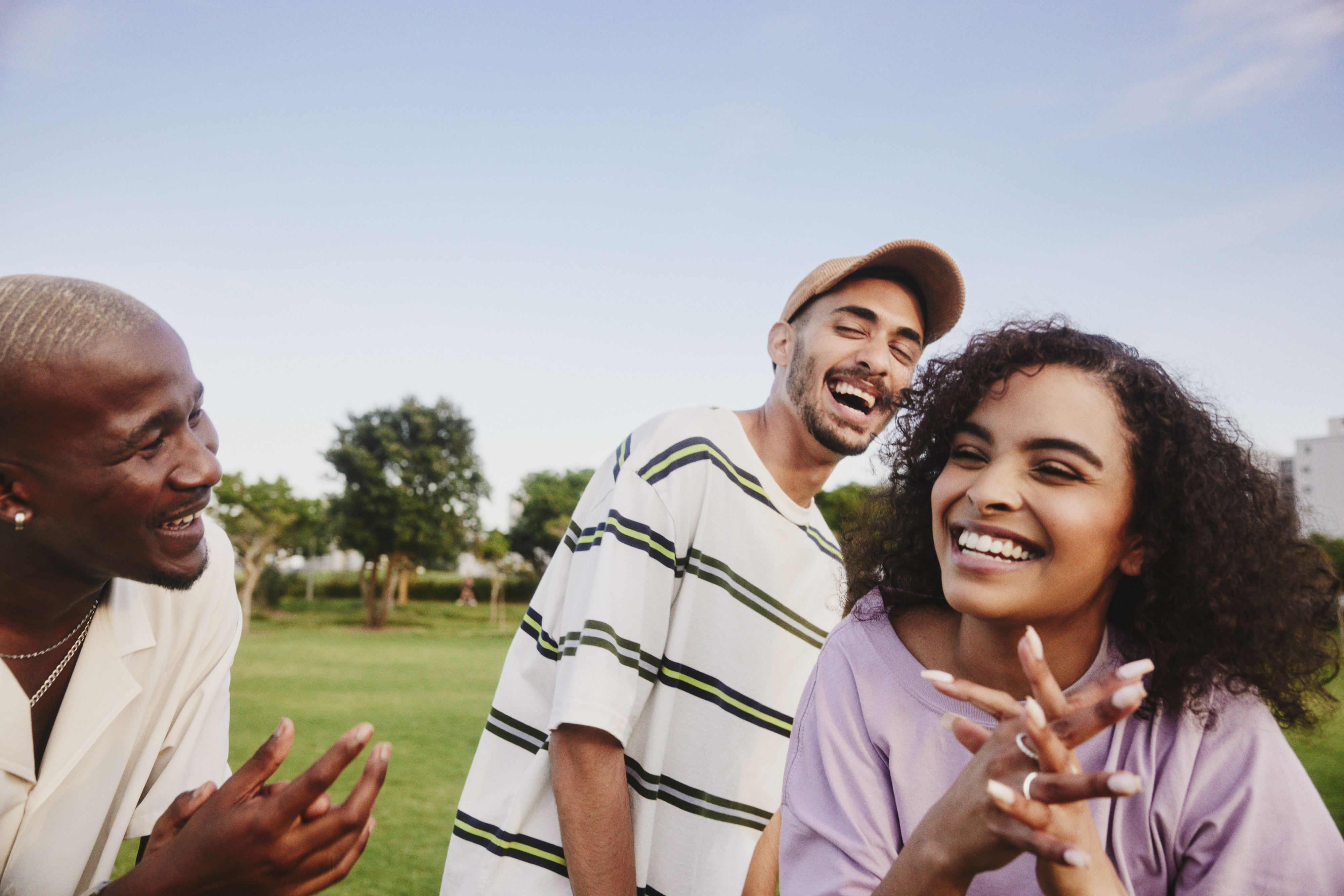 Man laughing to women in park