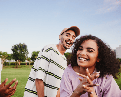 Man laughing to women in park