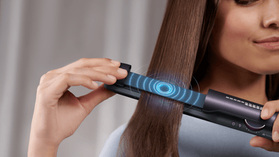 doamnă care își îndreaptă părul