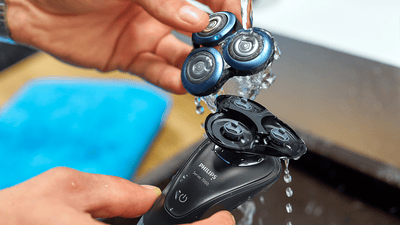 Maquinilla eléctrica colocada en el lavabo del baño