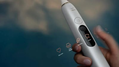 A close-up of a hand holding a silver Philips Next-Generation DiamondClean toothbrush.