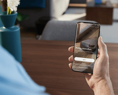 Човек, държащ смартфон с отворено приложение Philips HomeRun.