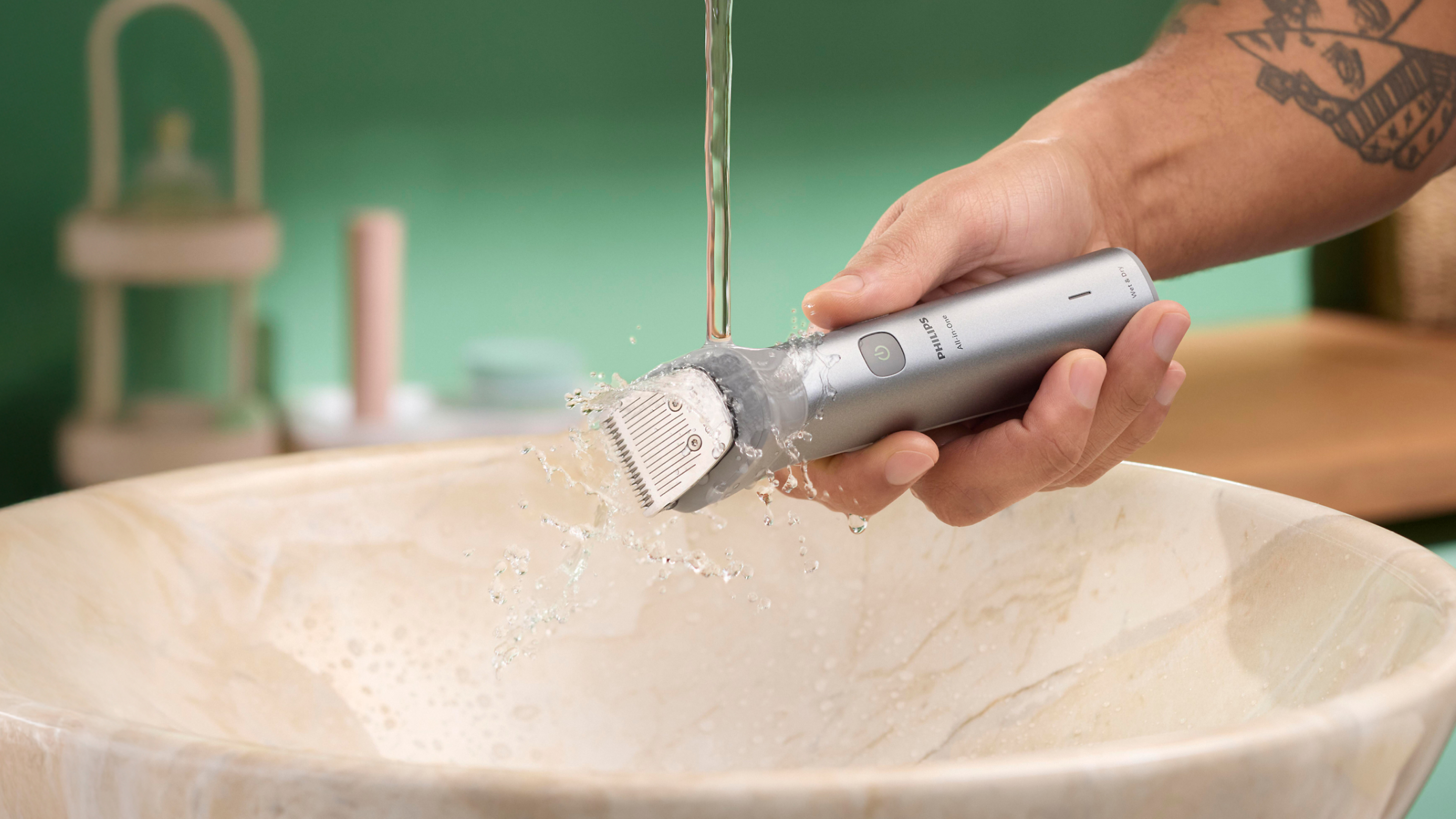 Trimmer being rinsed under running water