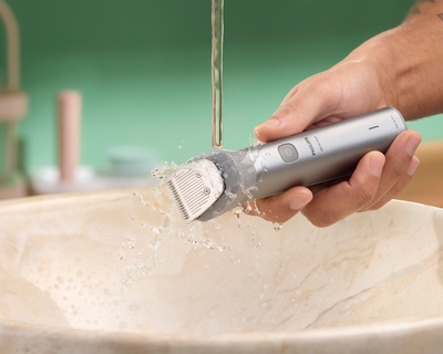 Trimmer being rinsed under running water