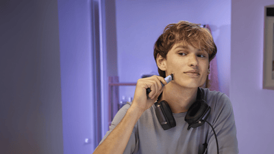 Prim-plan cu un bărbat care își aranjează barba cu OneBlade