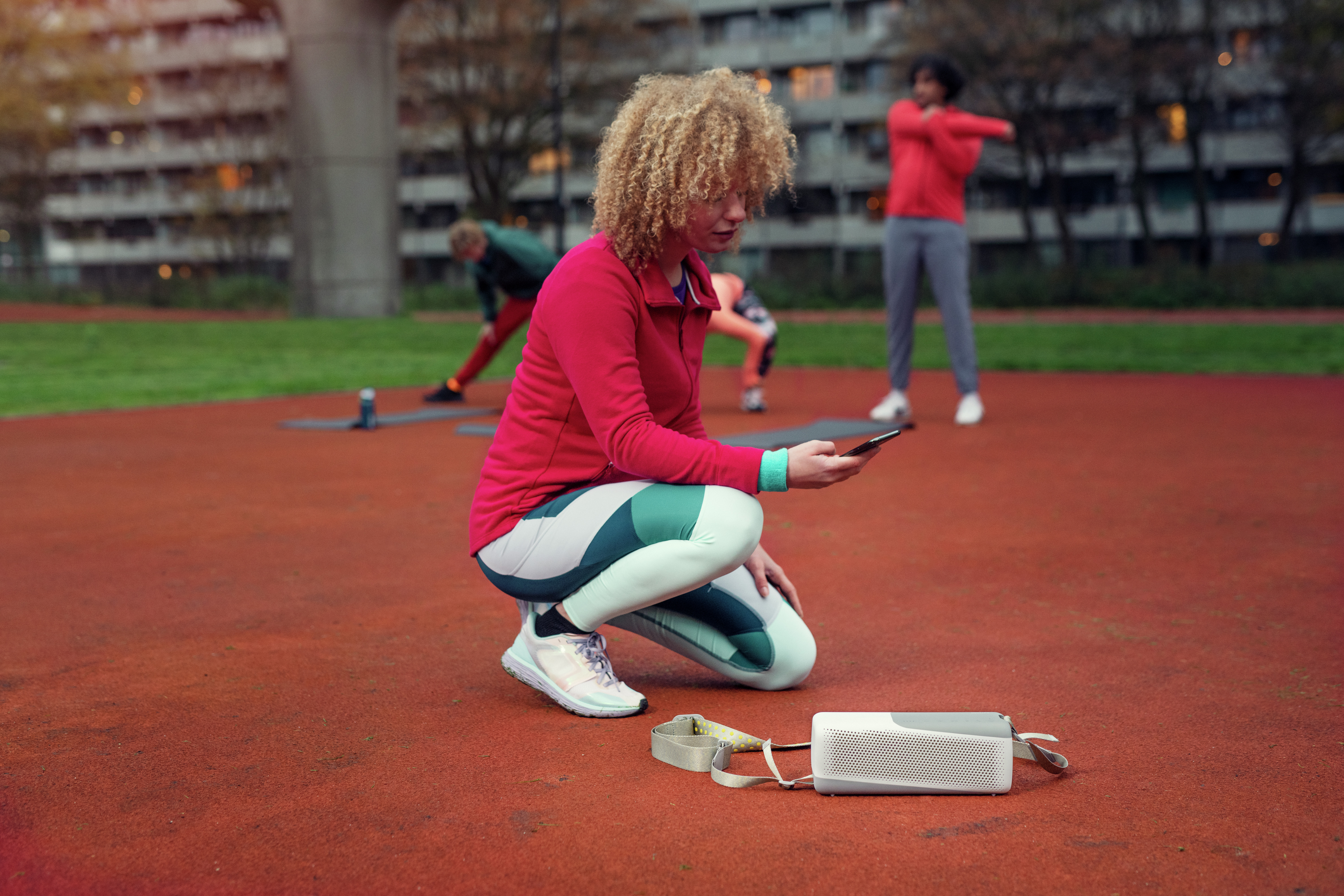 Žena se povezuje s Philips bluetooth zvučnikom na otvorenom