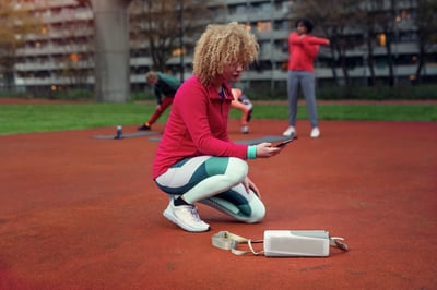Femme se connectant à son enceinte Bluetooth Philips à l'extérieur