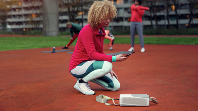 Žena se povezuje s Philips bluetooth zvučnikom na otvorenom