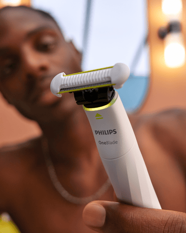 Zbliżenie kobiety używającej Philips OneBlade Intimate, pokazujące technologię świetlną informującą o konieczności wymiany ostrza