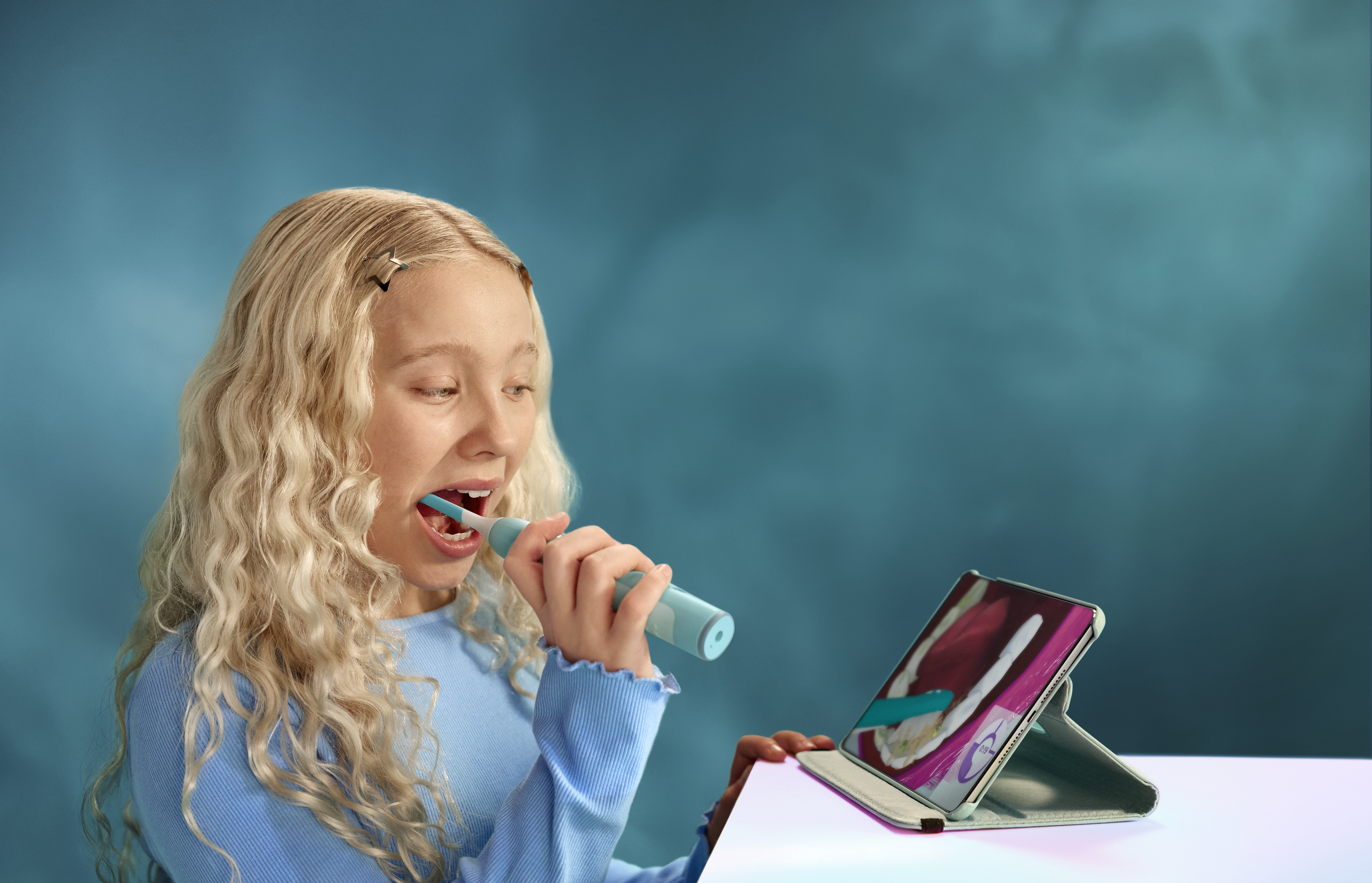  A child brushes her teeth with a Philips Sonicare for Kids Smart toothbrush, while using the Sonicare for Kids app.