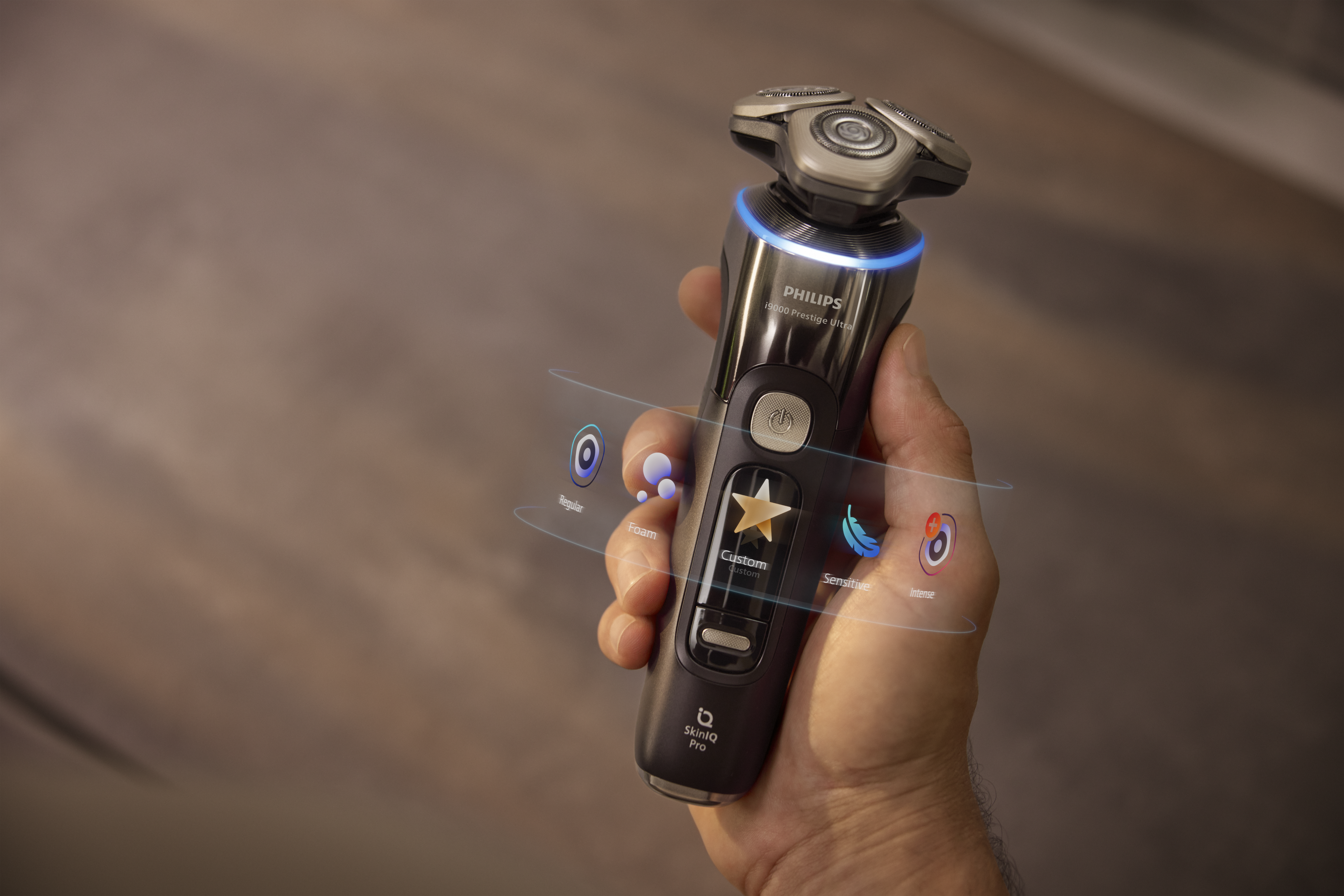Elektrický holicí strojek Philips držený v ruce se svítícím prstencem, zdůrazňující holení s podporou AI pro maximální pohodlí pokožky a přesnou péči.