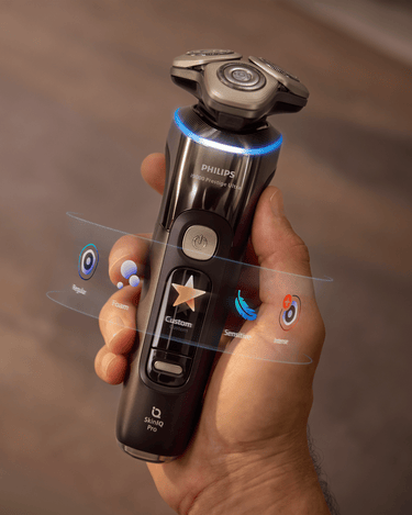 Philips electric shaver held in hand with glowing ring light, highlighting AI-powered shaving for ultimate skin comfort and precision grooming.