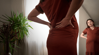 Siluetă a femeii însărcinate la fereastra răsăritului