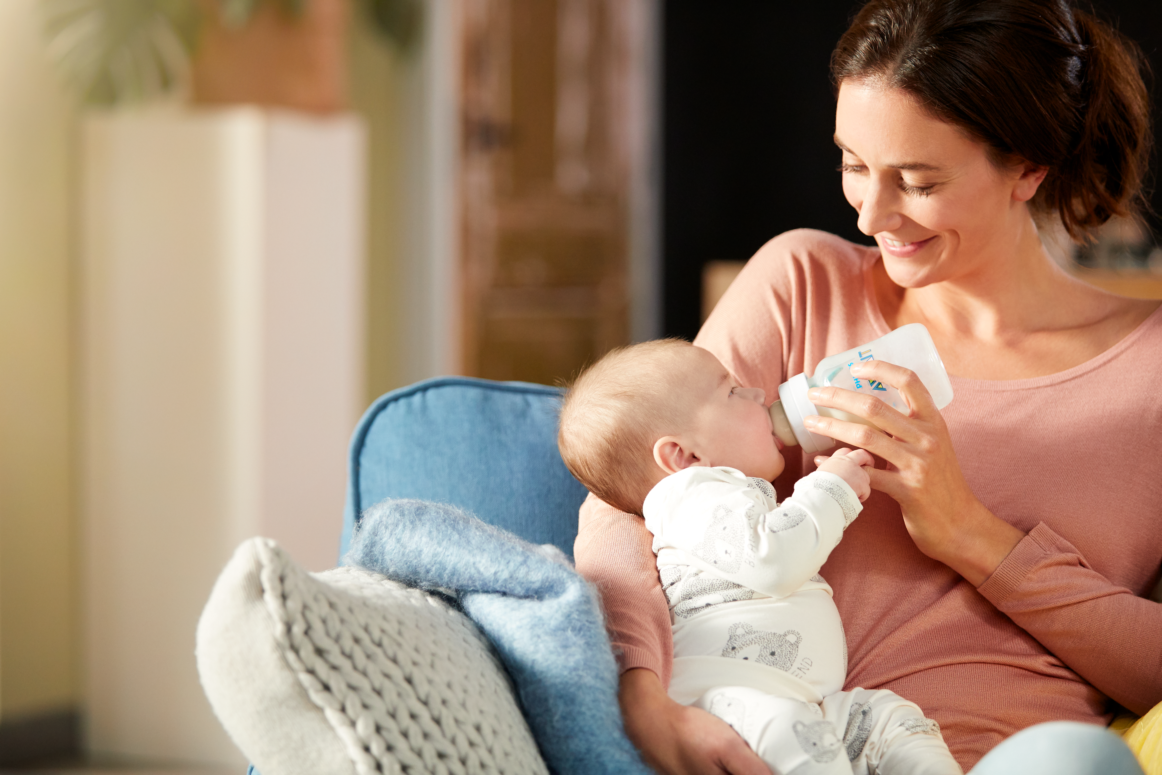 Woman feeding baby with Philips Avent anti-colic bottle with AirFree vent
