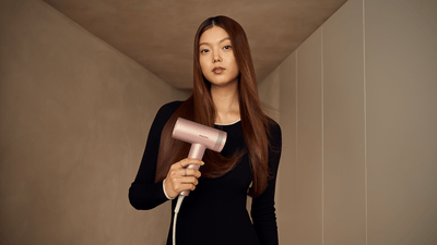 mujeres sosteniendo un secador de pelo
