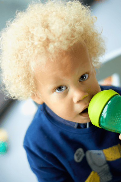 A kid drinking from a sippy cup