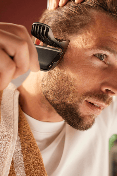 Mann führt einen Haarschnitt zu Hause durch