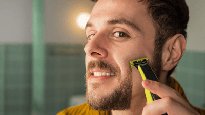Ujęcie z bliska: mężczyzna pielęgnujący brodę za pomocą urządzenia OneBlade