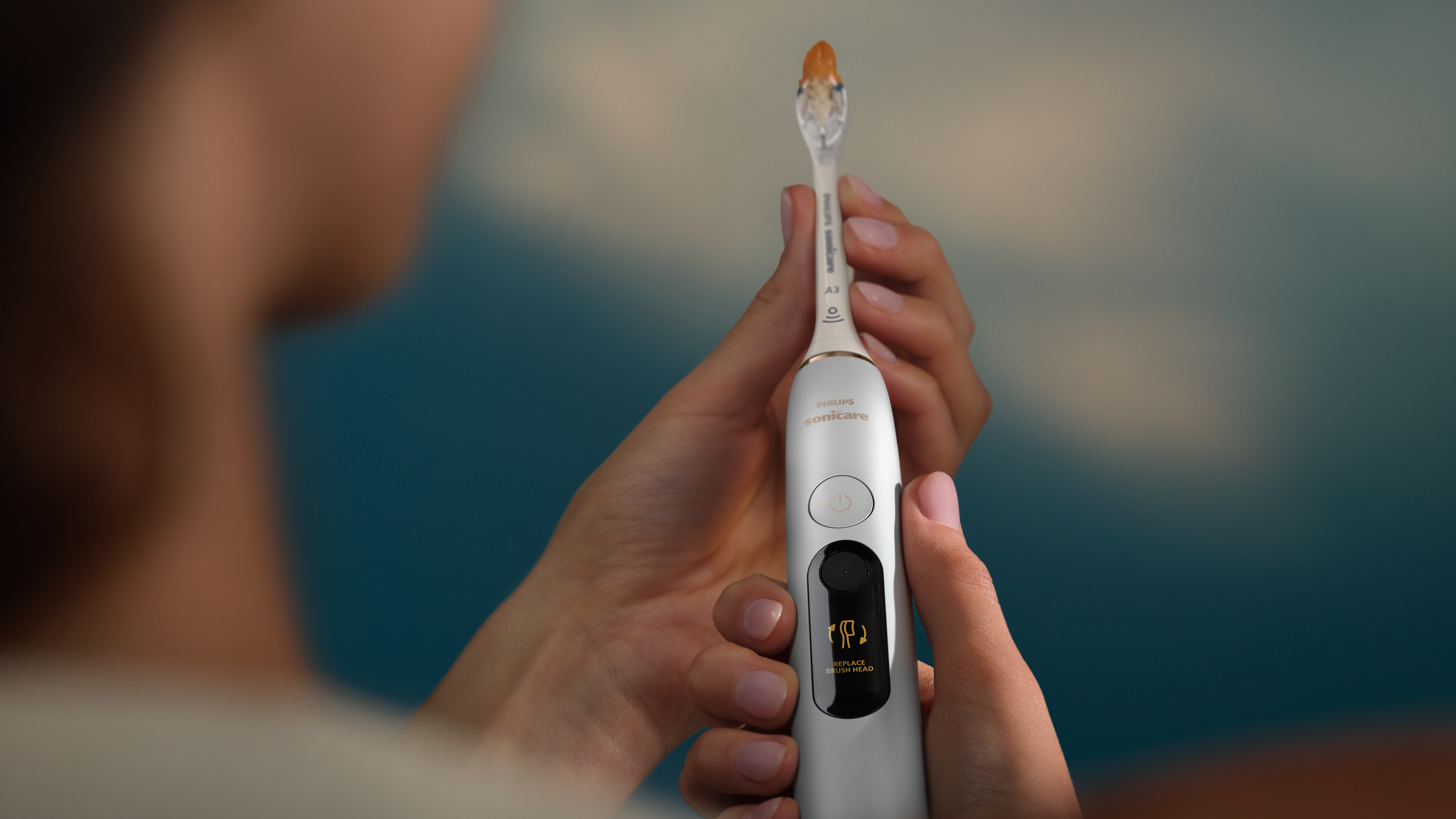 Una donna tiene tra le mani uno spazzolino Next-Generation DiamondClean color argento.