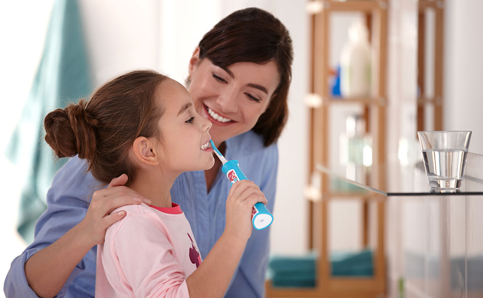 Dziewczynka myjąca zęby szczoteczką elektryczną Philips Sonicare for Kids