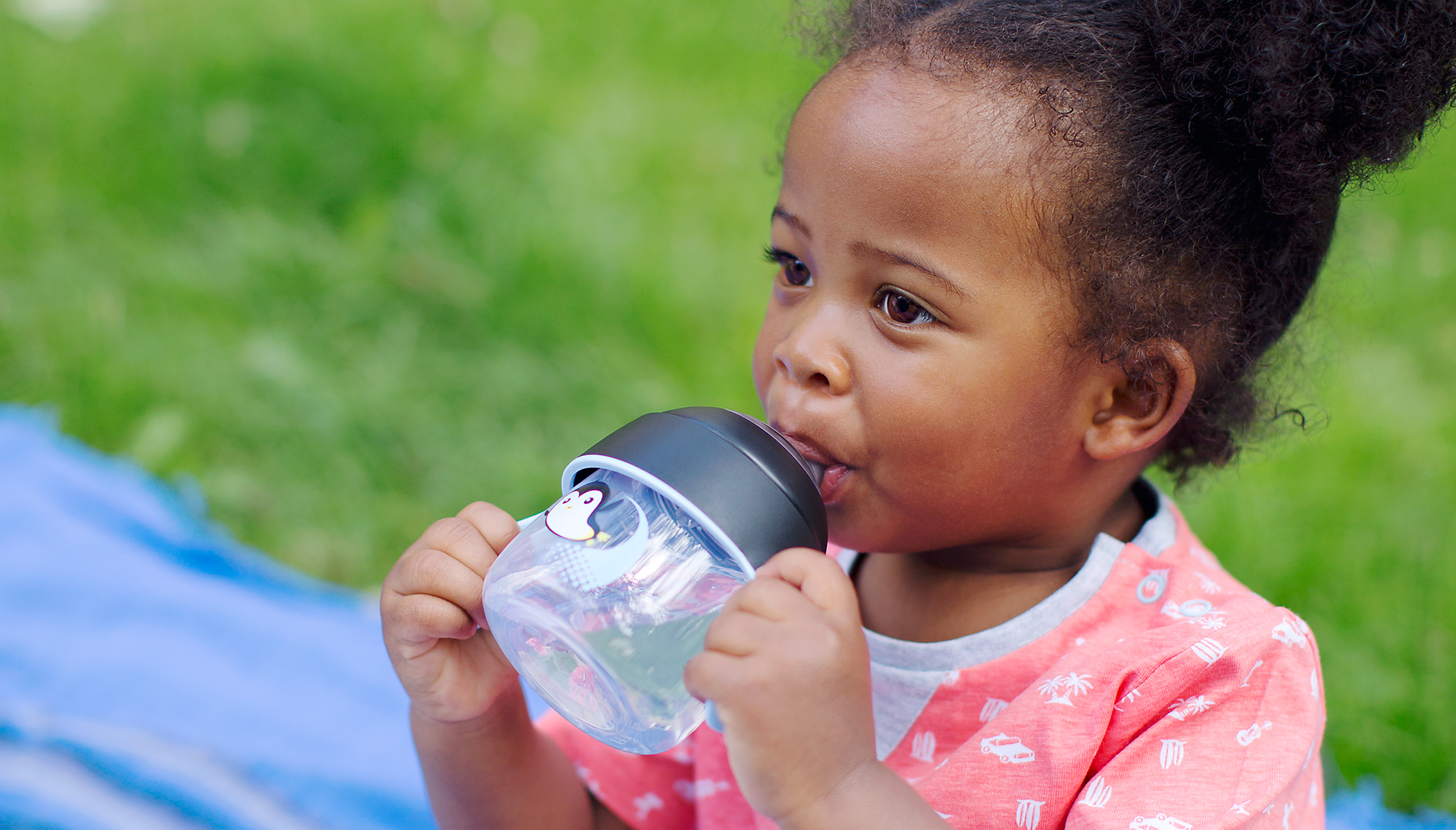 Criança pequena bebendo feliz e sozinha