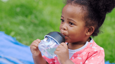 Copil mic care bea fericit și independent