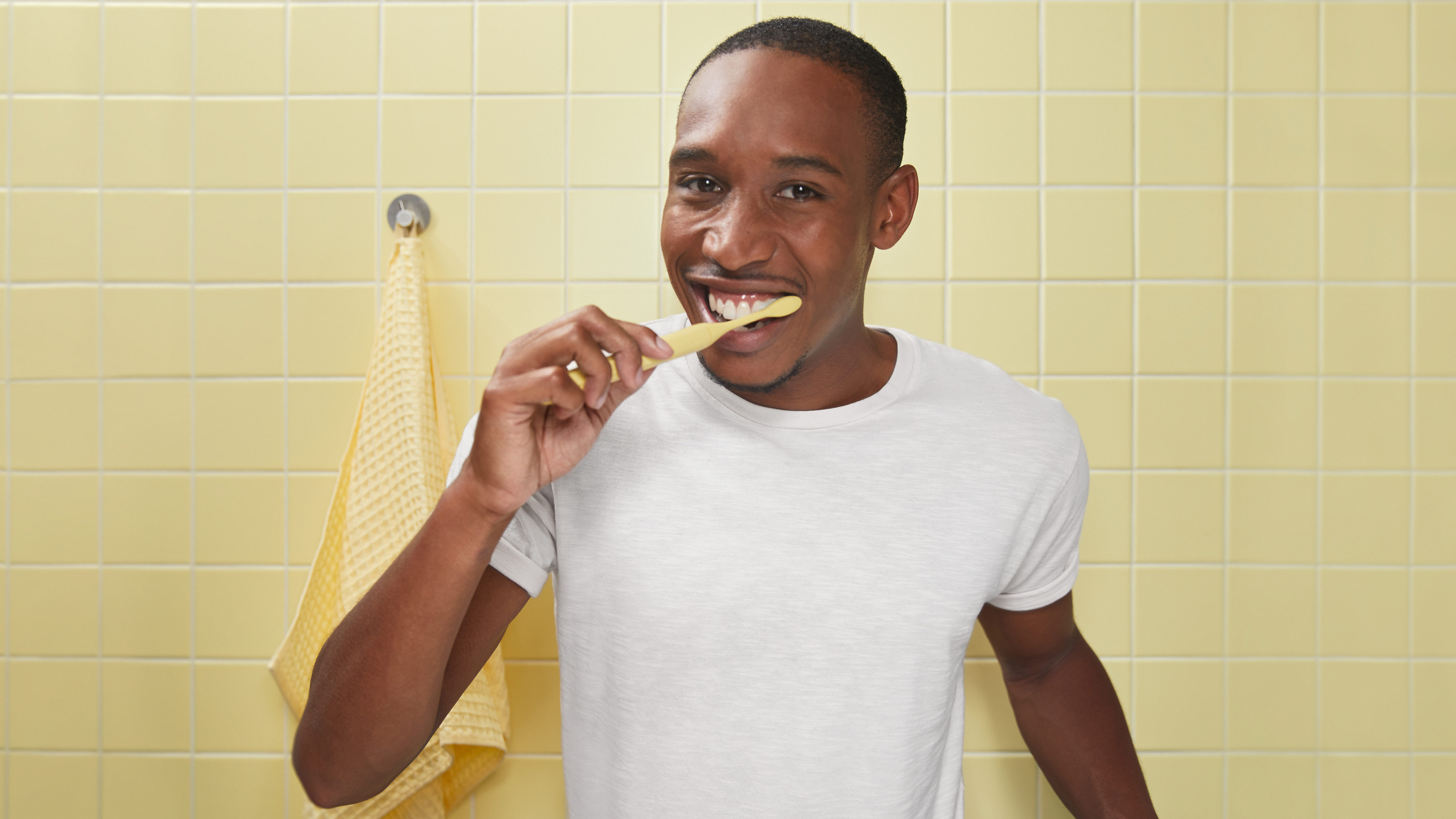 Hombre cepillándose los dientes con cepillo de dientes eléctrico