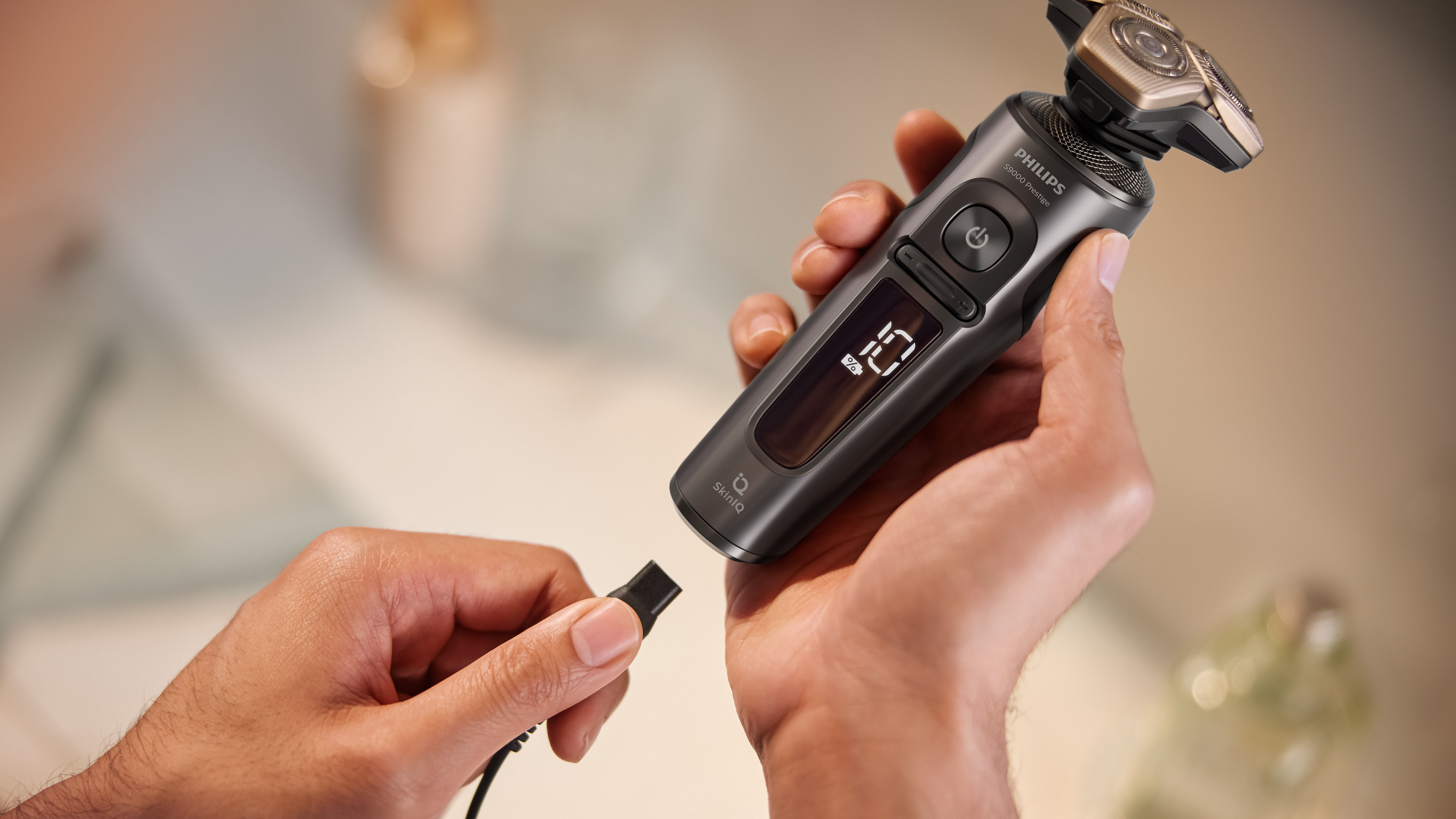 The Philips Shaver 9000 Prestige held in a hand about to be charged.