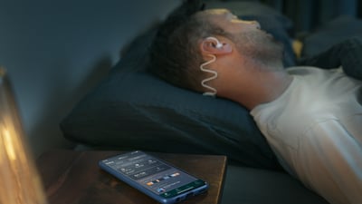 Man sleeping with Philips Sleep Headphones and the Kokoon app.