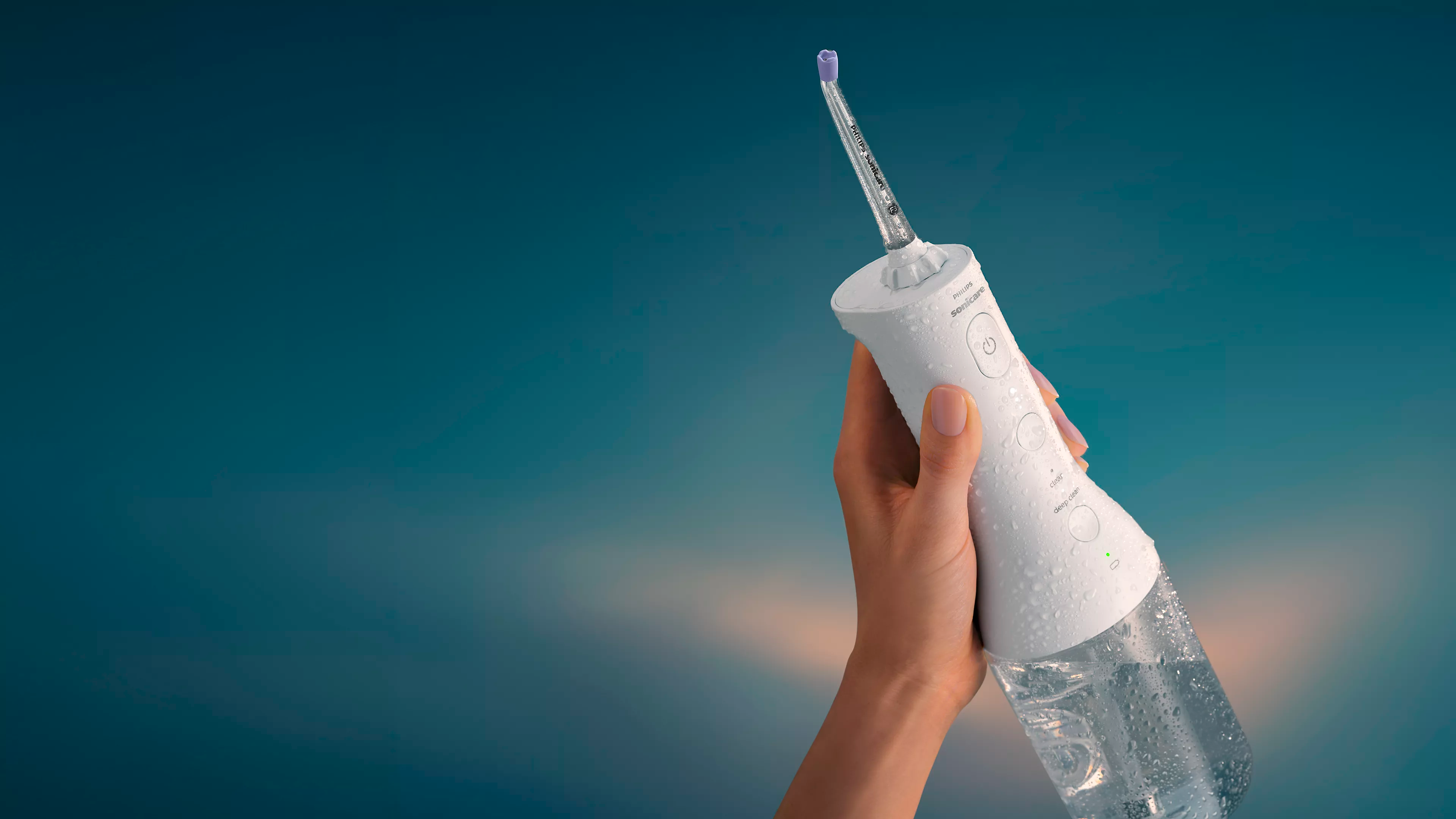 A Philips Sonicare Cordless Power Flosser being held.
