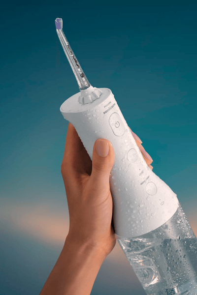 Een Philips Sonicare Cordless Power Flosser die wordt vastgehouden.