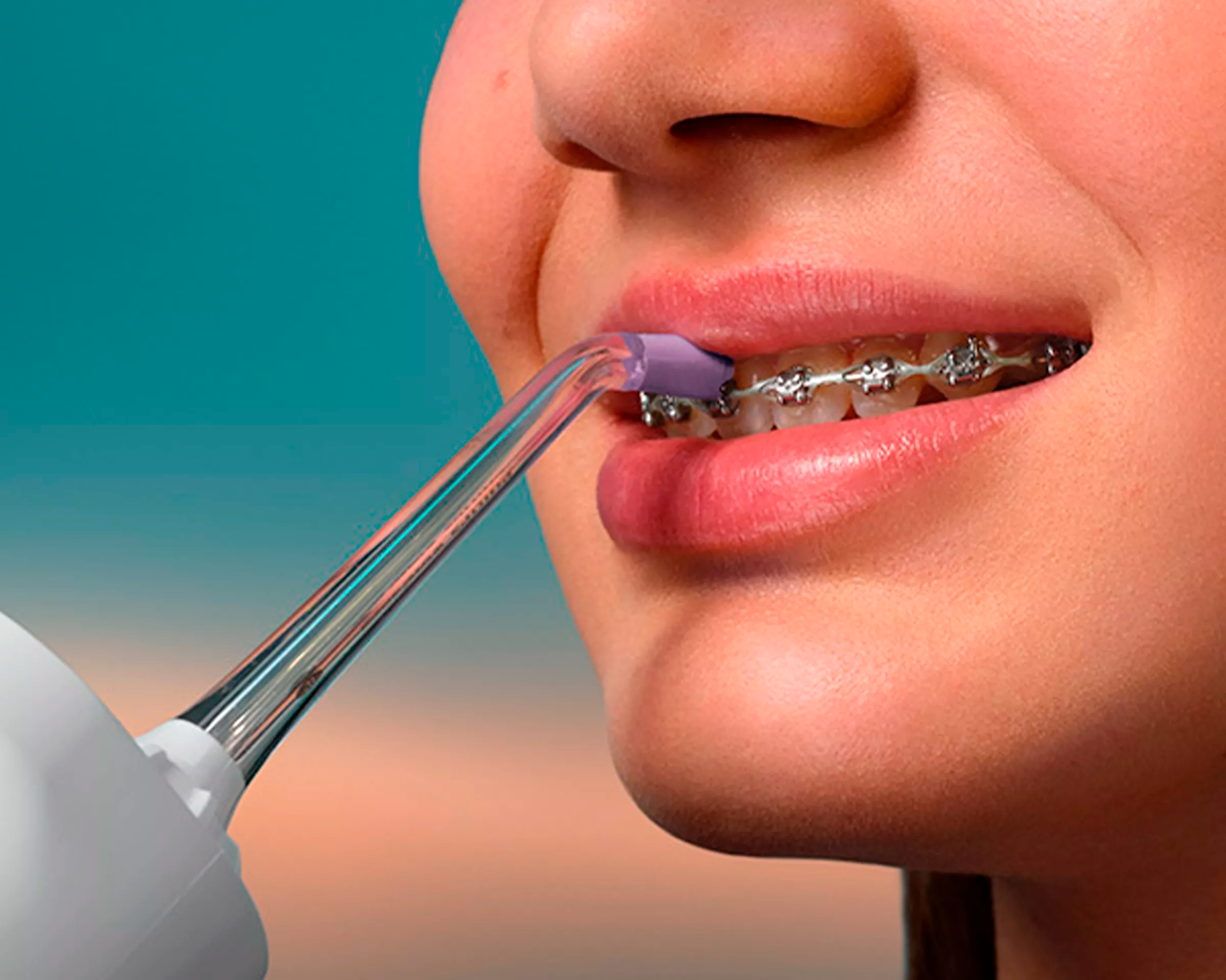 A patient with braces using a Cordless Power Flosser.