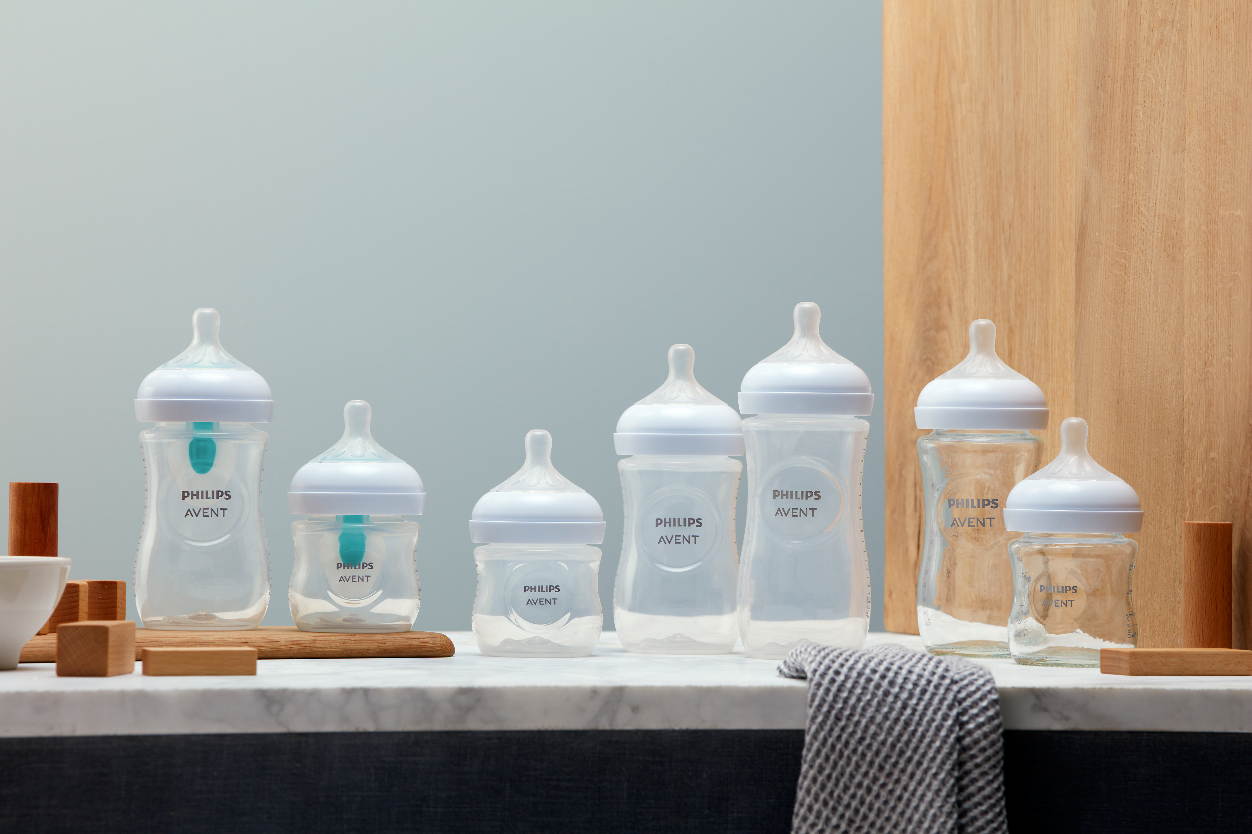 Different Philips Avent baby bottles on display next to each other on a marble surface.