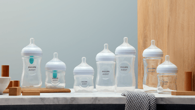 Different Philips Avent baby bottles on display next to each other on a marble surface.