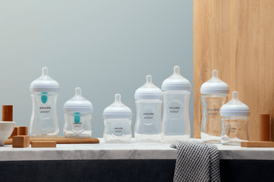 Different Philips Avent baby bottles on display next to each other on a marble surface.