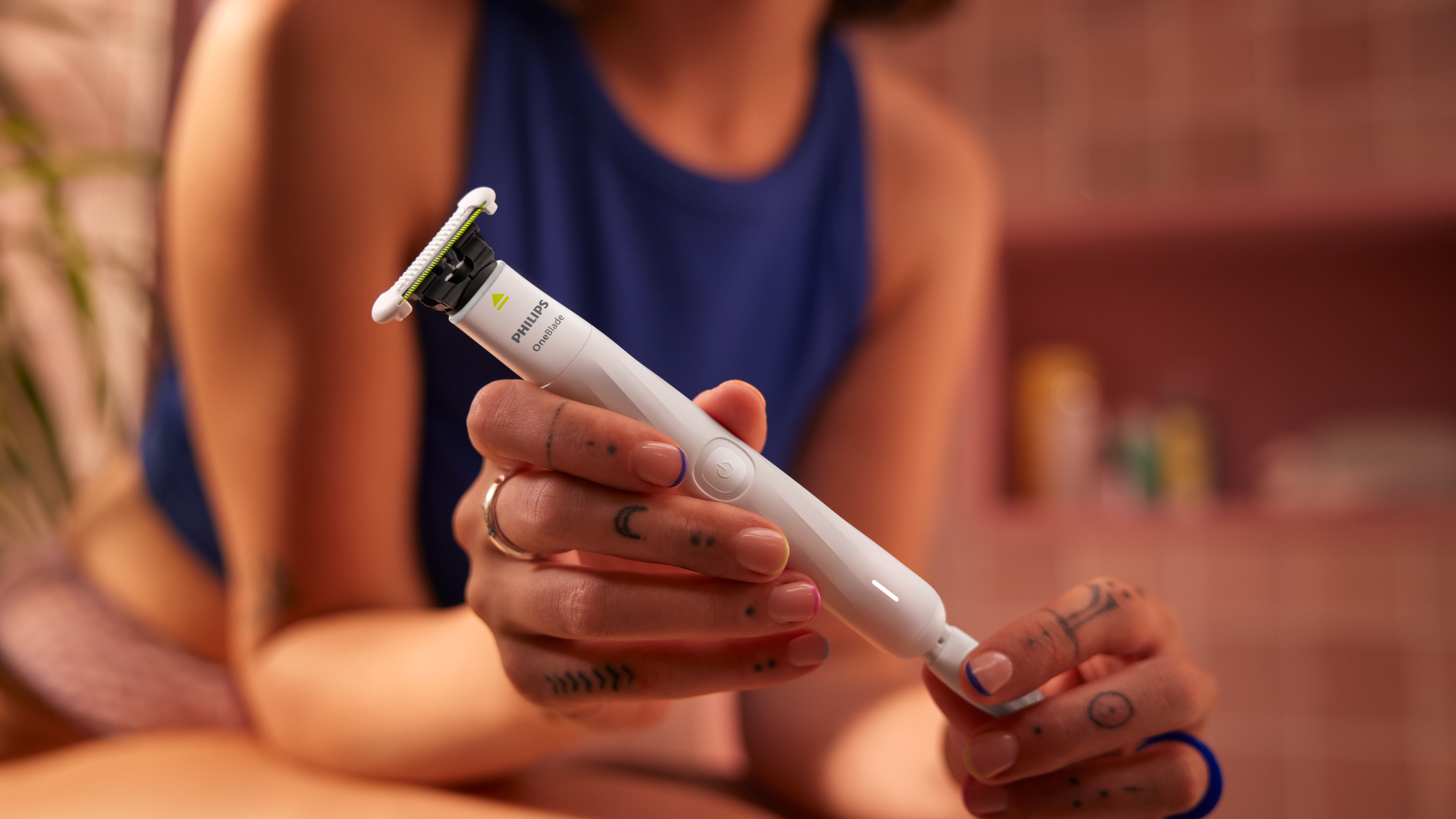 Zbliżenie na osobę trzymającą Philips OneBlade Intimate, podkreślające bezprzewodową konstrukcję z m...