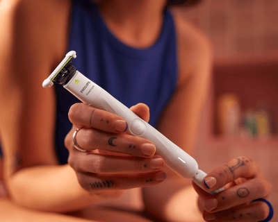 Zbliżenie na osobę trzymającą Philips OneBlade Intimate, podkreślające bezprzewodową konstrukcję z m...