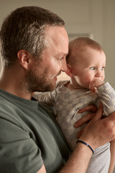 homem amamentando um bebê com uma mamadeira