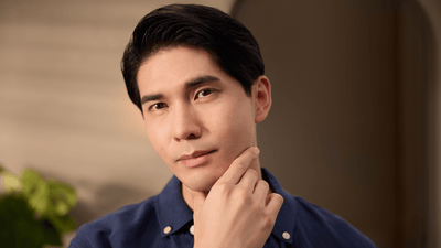 A man with a cleanly shaved face with no shaving pimples and one hand on his chin poses directly at the camera.
