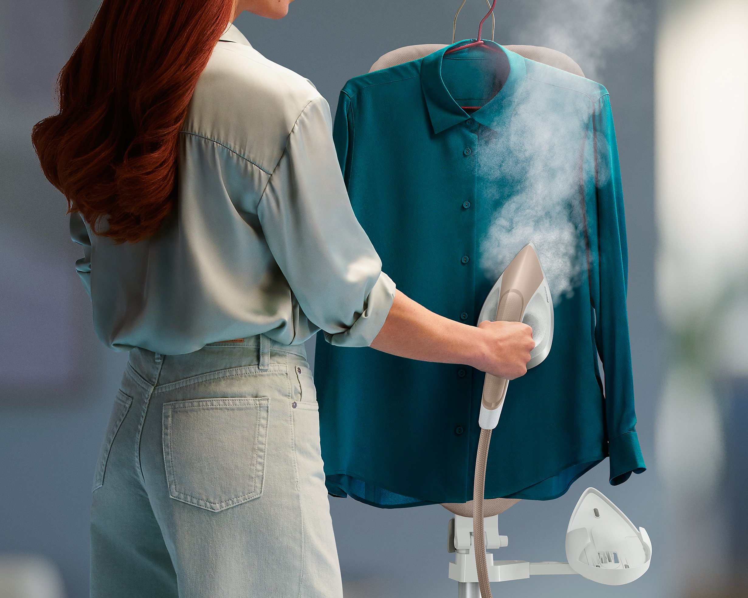 žena žehliaca košeľu parou