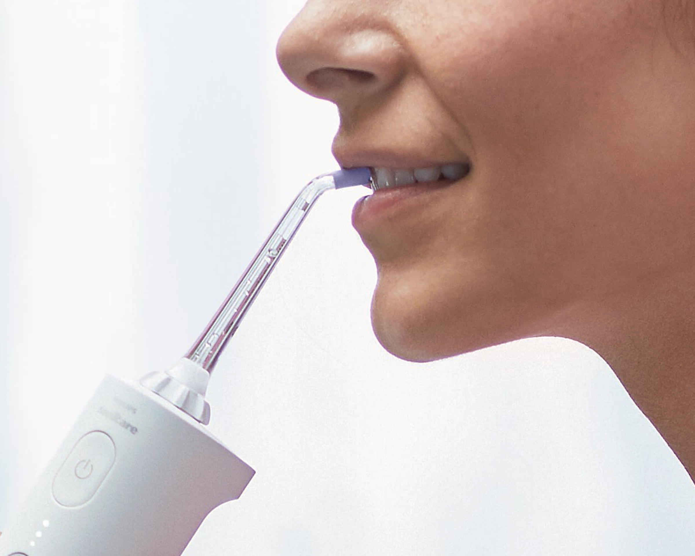 Patient uses the power flosser on front teeth