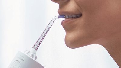 Patient uses the power flosser on front teeth