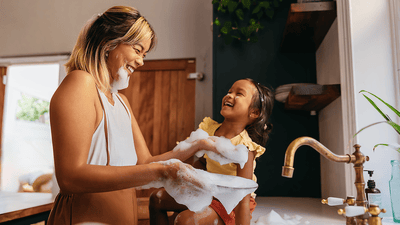 Copil jucăuș râzând lângă chiuveta din baie