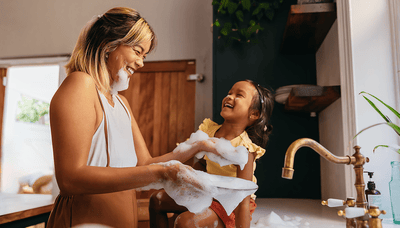 Playful child laughing near bathroom sink