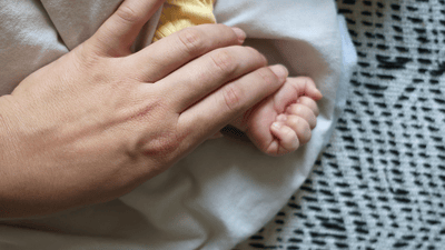 Szczegół rodzica trzymającego dziecko blisko kocem