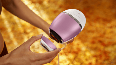 A close-up product image of a pink Philips Lumea Sunstone 8000 being held up to the camera.