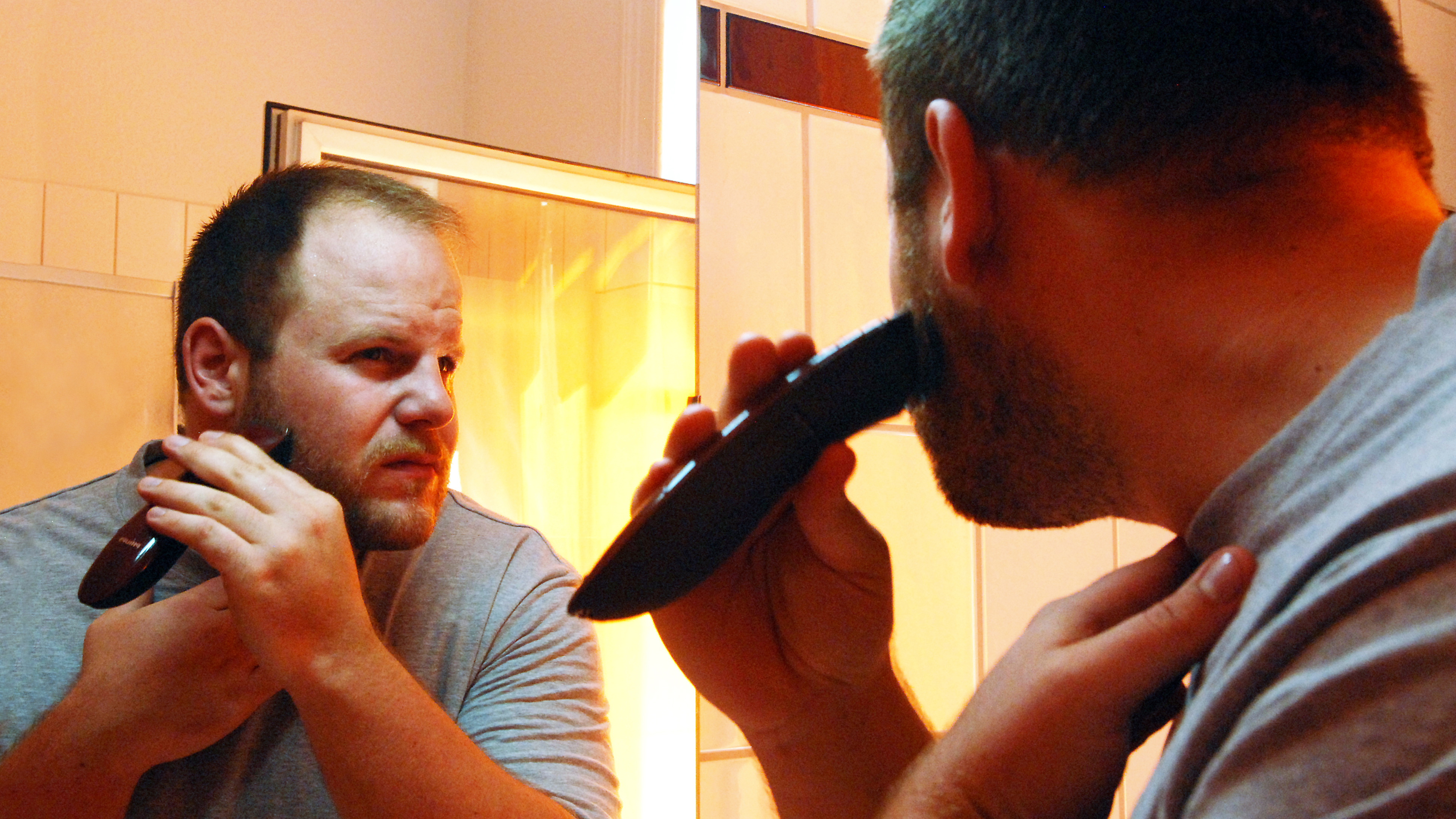 Muškarac se brije ispred ogledala