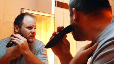 Bărbat bărbierindu-se în fața oglinzii